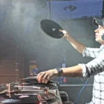 Andy C lifting a record off a turntable mid-set