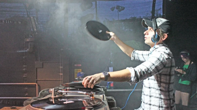 Andy C lifting a record off a turntable mid-set