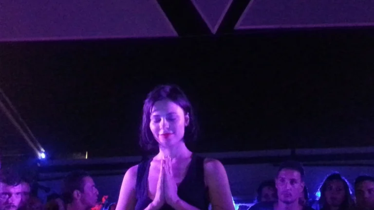 Nina Kraviz with hands pressed together at the end of a set