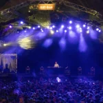 Peggy Gou performing to a large crowd on a festival stage